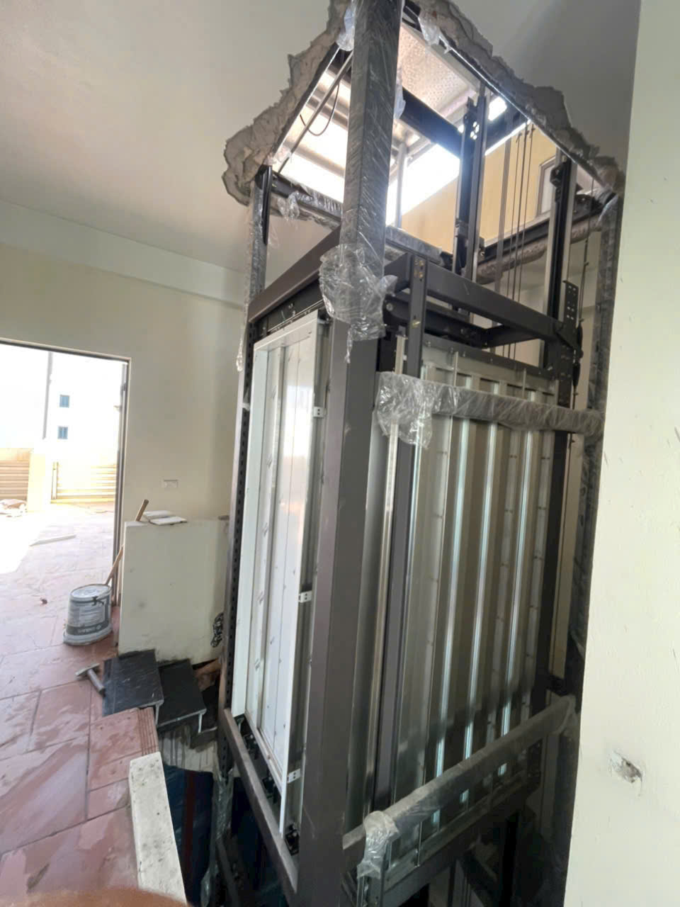 Lắp đặt khung thang máy gia đình đang thi công dở trong nhà nhiều tầng